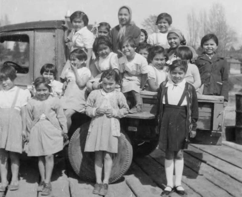 Group of students sitting and standing by truck from Kupersland School