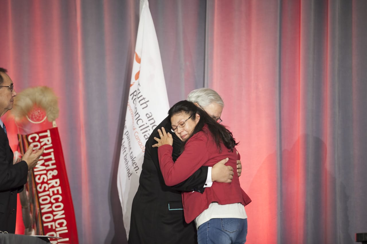 People hugging on stage at TRC of Canada's Closing Ceremony