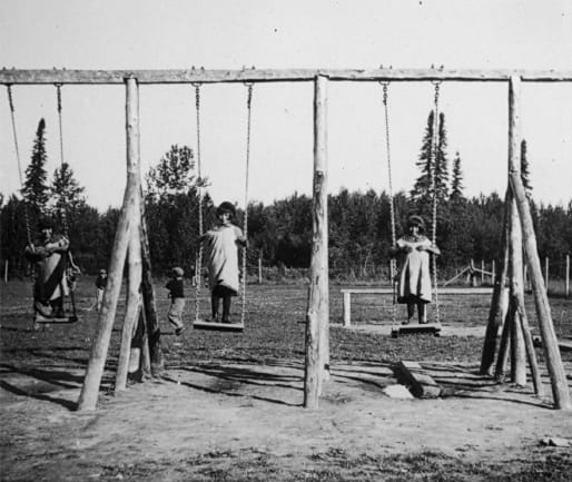 Group of children playing on swing set.