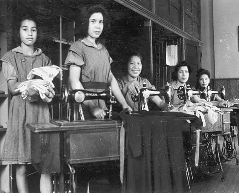 Group of people sewing on machines in Mohawk Institute school