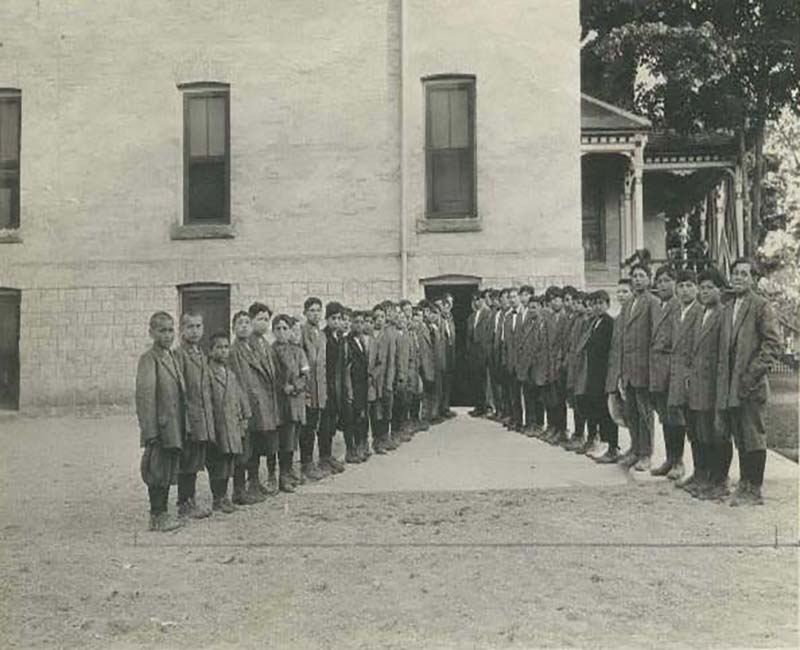 Group of people posing for photo outside of a Mount Elgin school building