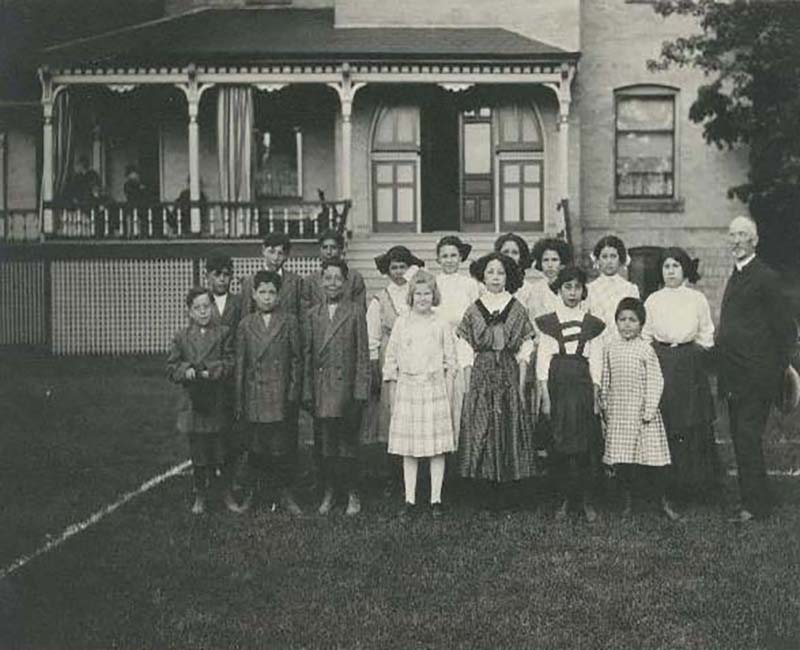 Group of people posing for photo outside of a Mount Elgin school building