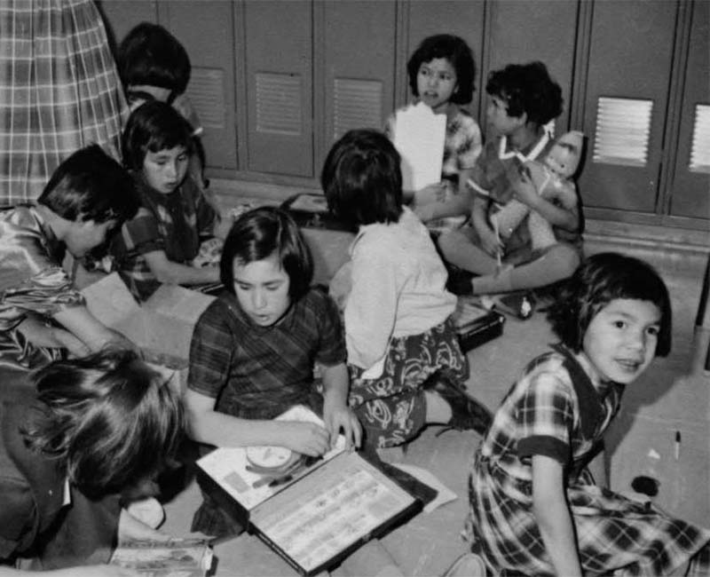 Group of students sitting on floor by lockers in Pointe Bleue school