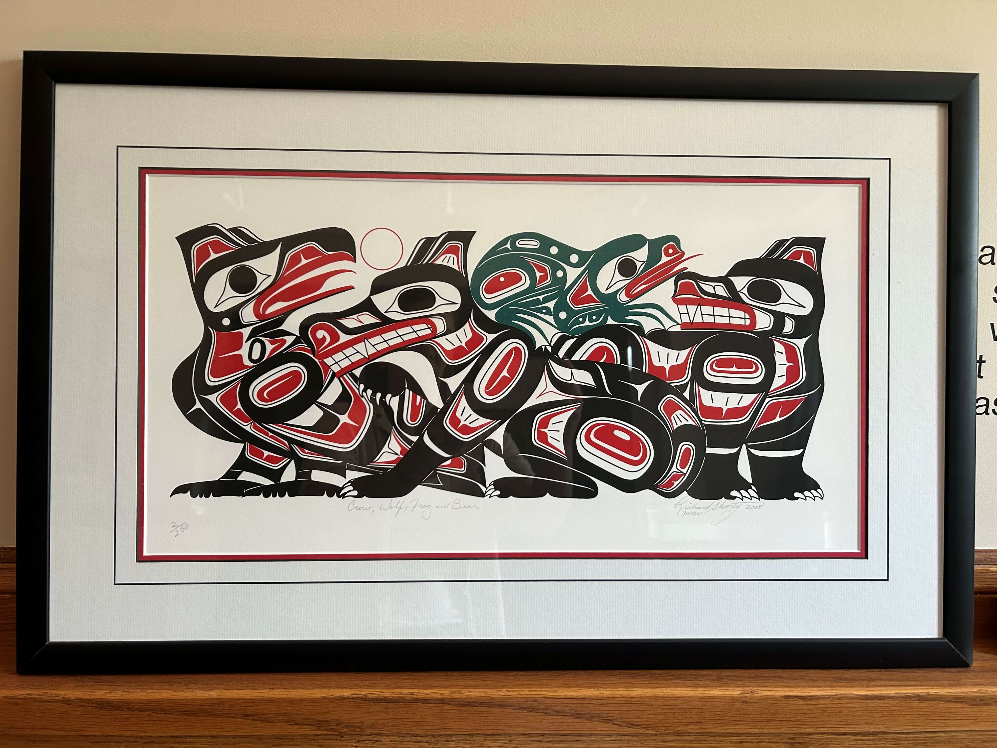 A painting titled "Totem" by Richard Shorty, featuring four stylized clan animals: Raven (light), Wolf (provider), Bear (strength), and Frog (land/water connection).